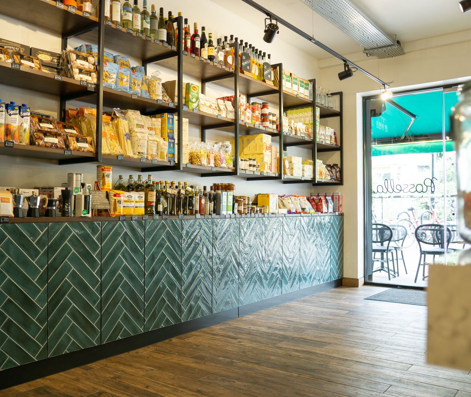 Display Area, Extra storage behind these tiled cabinet doors. Wall gantry shelves and display worktops are all stained oak. 
